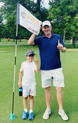 Austin Snedeker, left, holds the ball he made a hole-in-one with Tuesday at the Little Course at Corner Lane, while his dad Brandt caddied for him.